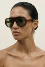 Person wearing AVIATOR sunglasses with a neutral background