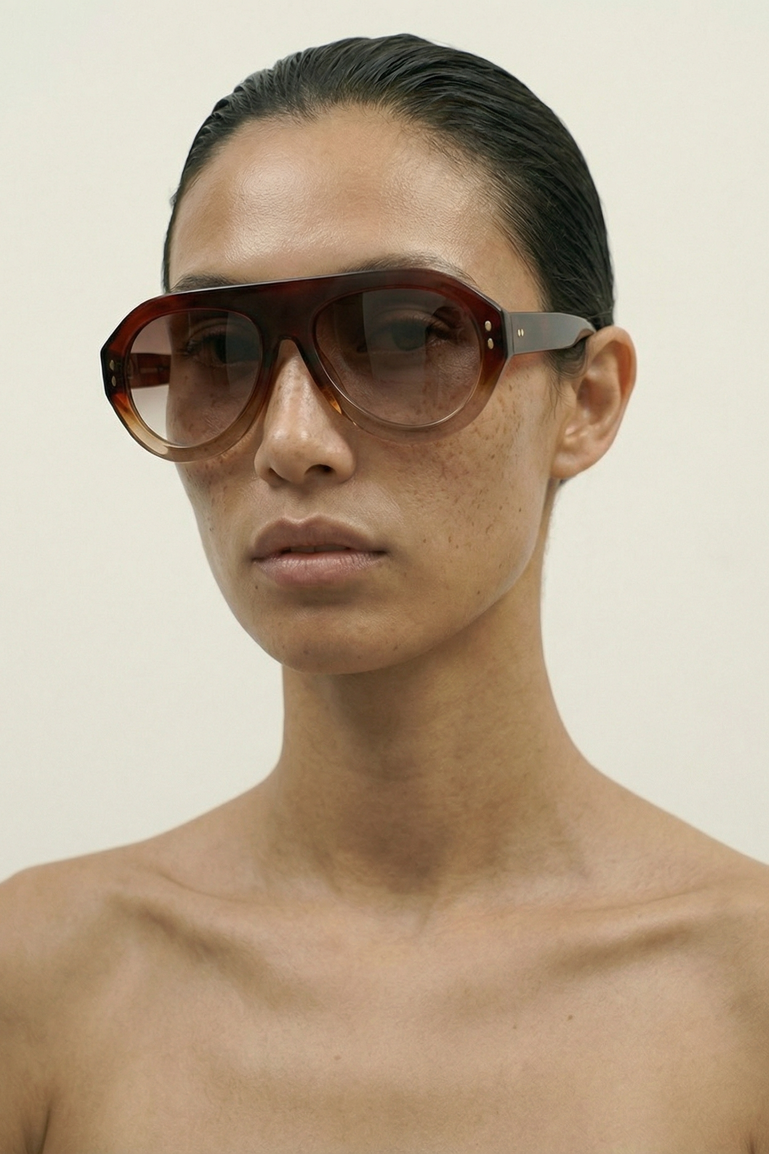 Person wearing MAROON AVIATOR sunglasses against a plain background